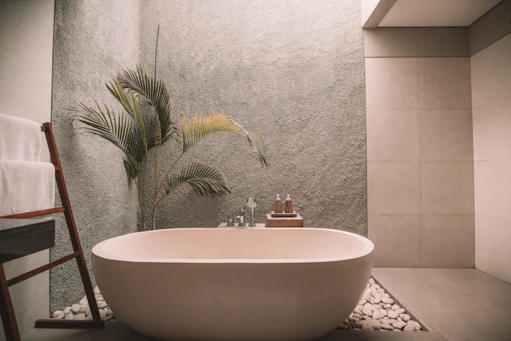 Freestanding stone-effect bath against a textured feature wall