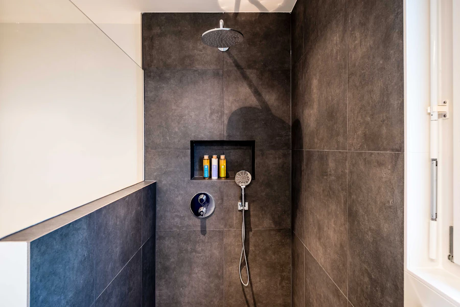 Fully tiled wet room style shower with a rainfall head and a recessed niche
